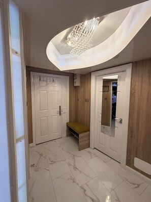A hallway with a marble floor, a bench, a wooden wall, and a door with a mirror. -     Wow! River Views + Private Cinema (Limerick)