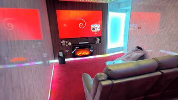 Un salon moderne avec une moquette rouge, un canapé en cuir et un téléviseur à écran plat.