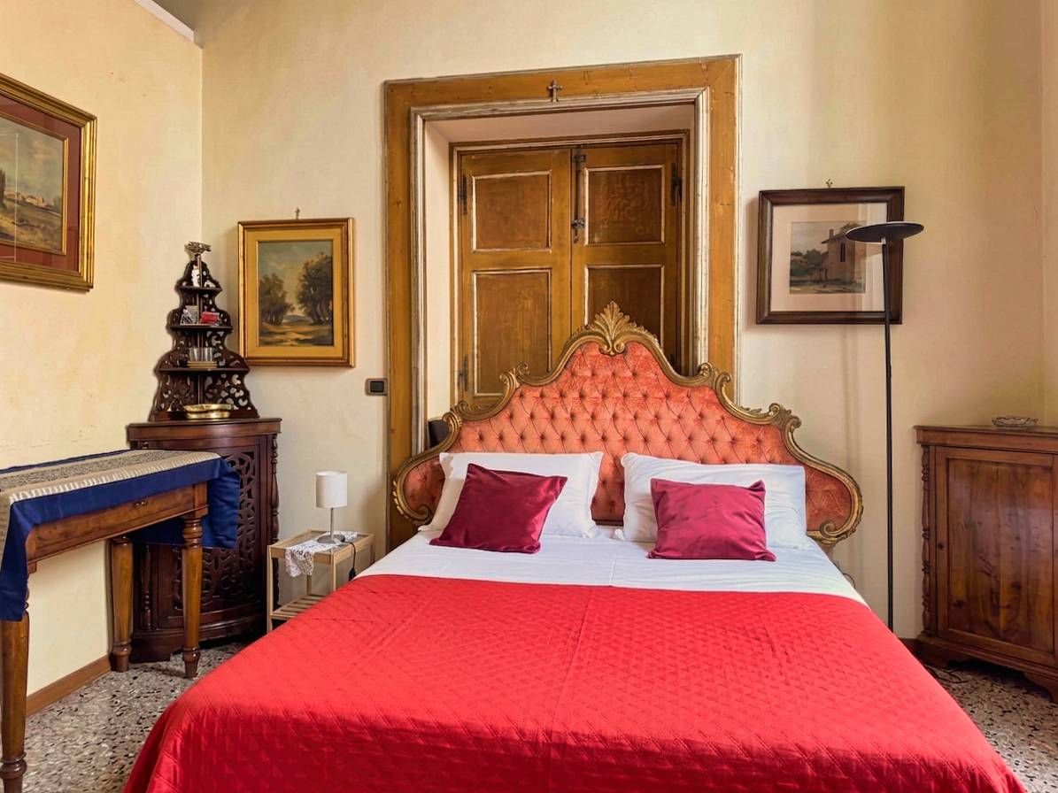 Una camera da letto con un letto grande, una testiera in legno, una scrivania e una sedia.