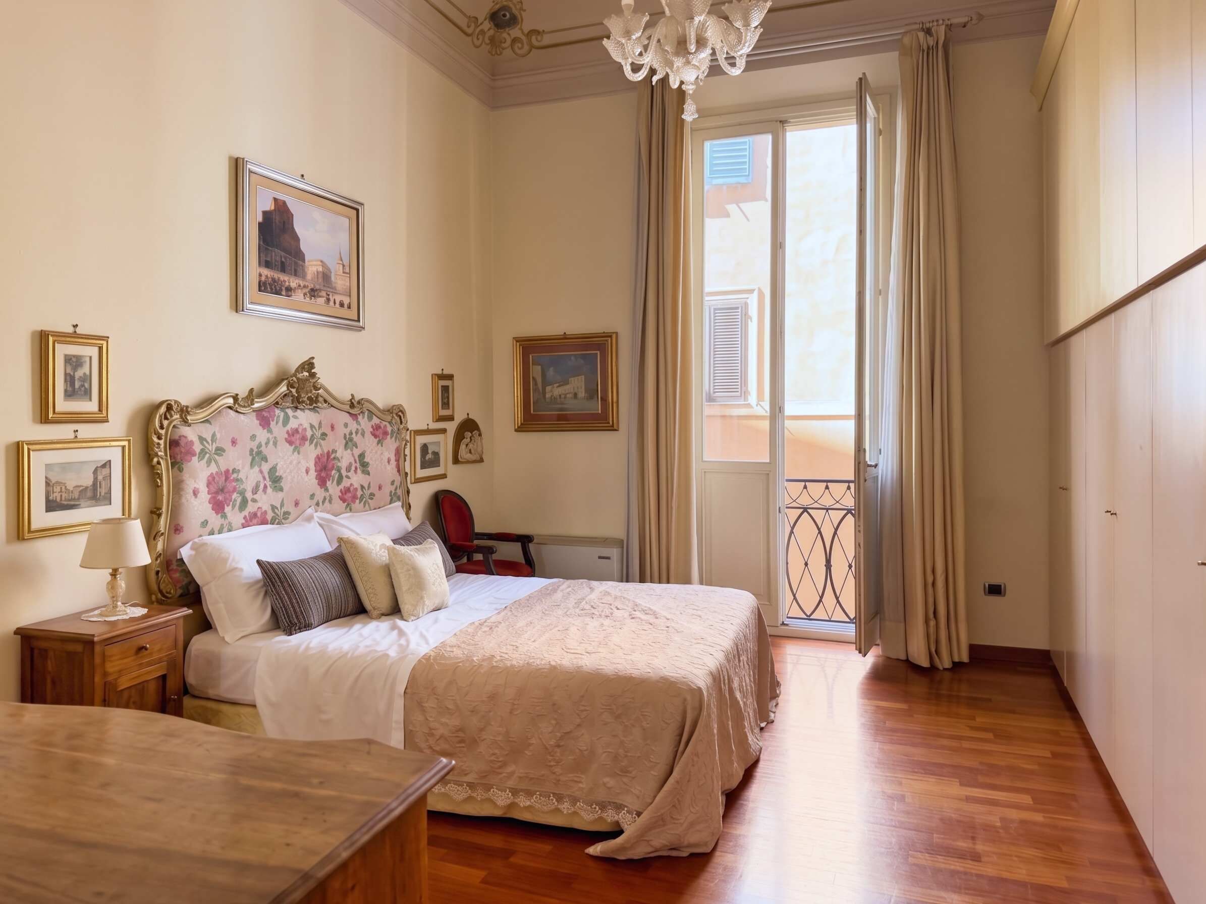 Une chambre d’hôtel avec un lit, une table de chevet, une lampe et une vue sur l’extérieur par une fenêtre.