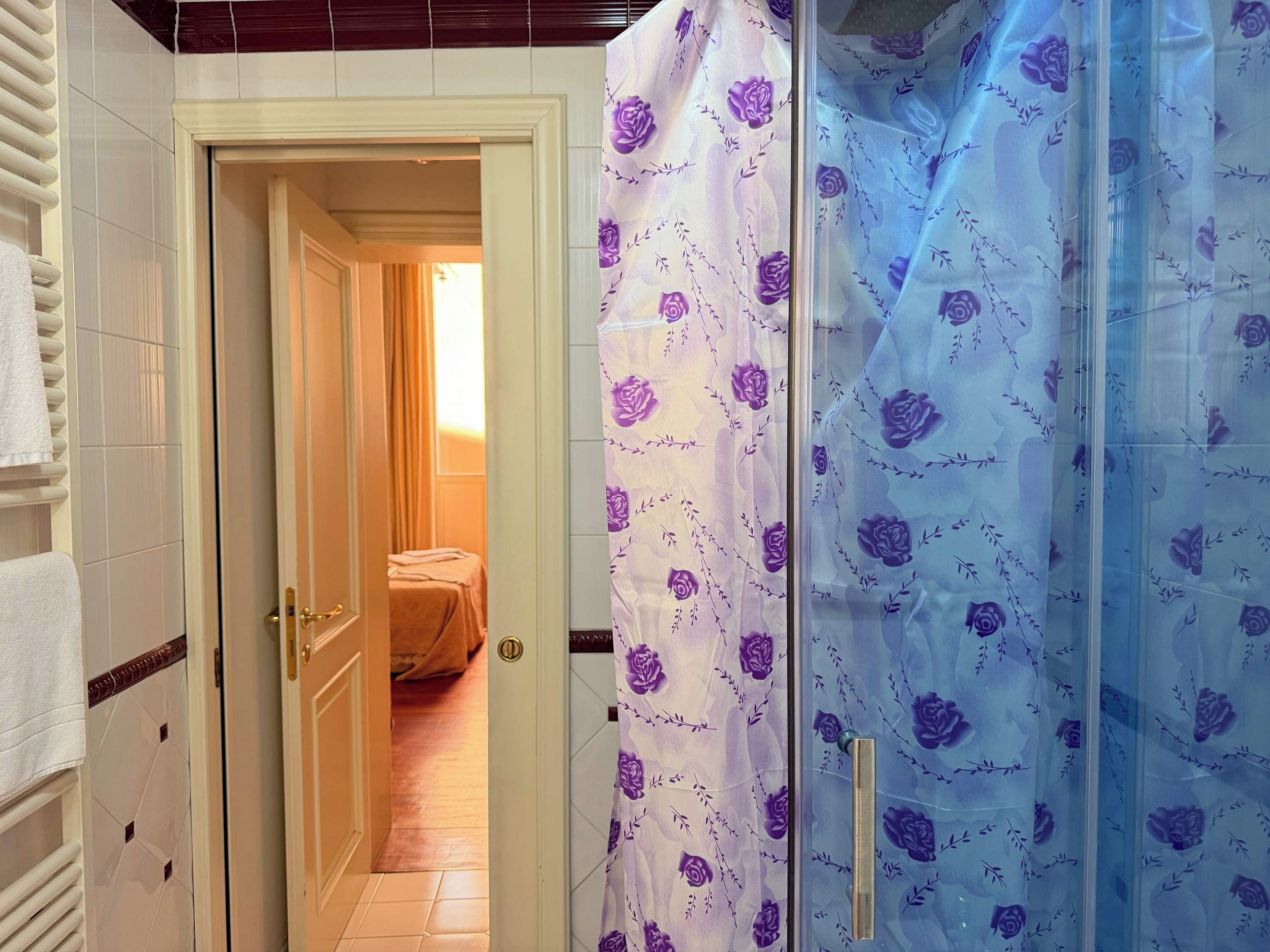 A bathroom with a shower curtain featuring a floral pattern.