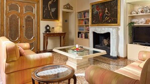 Un salon avec une cheminée, des étagères à livres et un téléviseur.