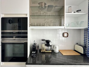 Eine Küche mit Siemens-Backofen, Kaffeemaschine, Wasserkocher und Toaster.
