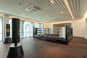 A boxing ring with a 'Title Legendary Bang-Tao' banner, a punching bag, and a mirrored wall. - Bang Tao - Spacious Private Balcony (Tambon Choeng Thale)