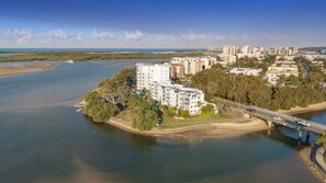 A coastal residential area with modern apartment buildings, a bridge, and a river. - Charming 2-bed Coastal Haven Near Esplanade (Sunshine Coast)