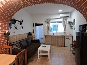 A compact living space with a kitchen, dining area, and a seating area with a sofa and a table. - Fully furnished apartment next to the subway, near the beach (València)