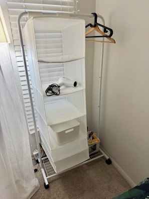 A white storage unit with shelves and drawers, a hanging rack, and a power cord. - Luxe & Modern 1-bed with panel living space w Pool, Hot tub, Gym -Marina del Rey (Marina del Rey)