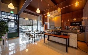 Een modern café interieur met een marmeren toonbank, een zithoek en hangende吊灯.