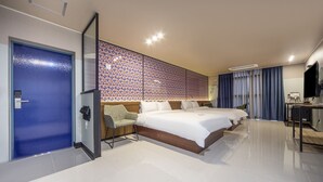 Quarto de hotel com uma cama grande, uma escrivaninha e um guarda-roupa.