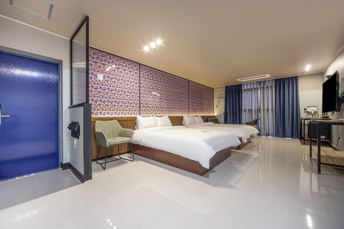 Een hotelkamer met een groot bed, een bureau en een kledingkast.