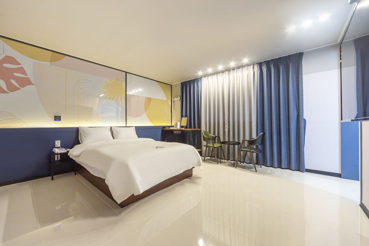 Een moderne hotelkamer met een groot bed, een bureau en een stoel.