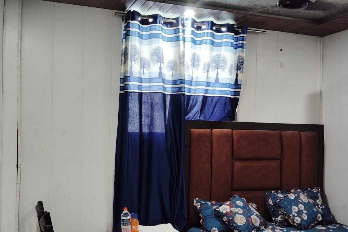 A bedroom with a bed, a desk, and a chair.