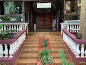 Une entrée imposante, agrémentée d’une enseigne « Bienvenue », d’un escalier et d’une balustrade.