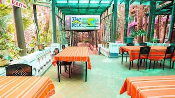 An outdoor dining area with tables and chairs, a sign for 'The Deck', and an exit sign.