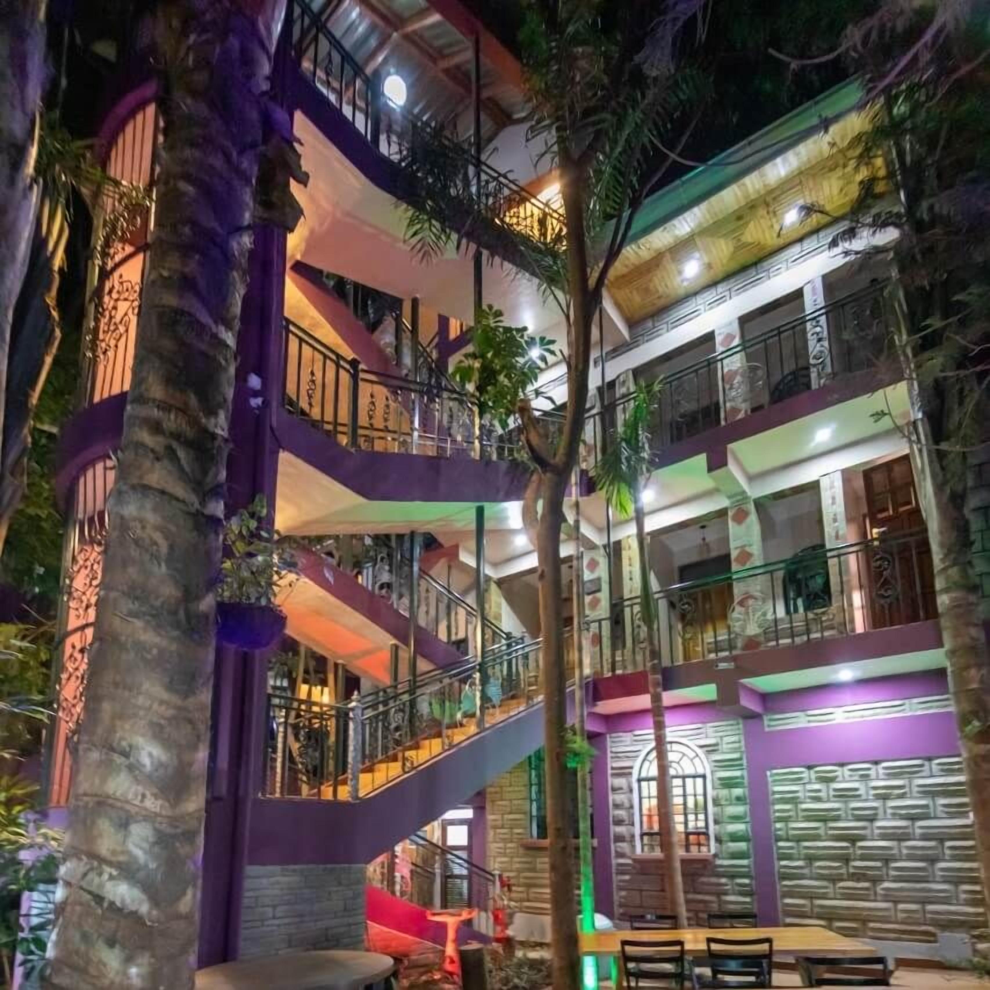 Un edificio de varios niveles con balcones, escaleras y zonas de estar interiores.