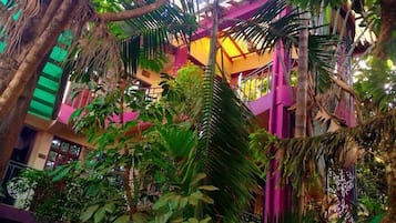 An indoor garden with dense foliage and a multi-level structure with balconies.