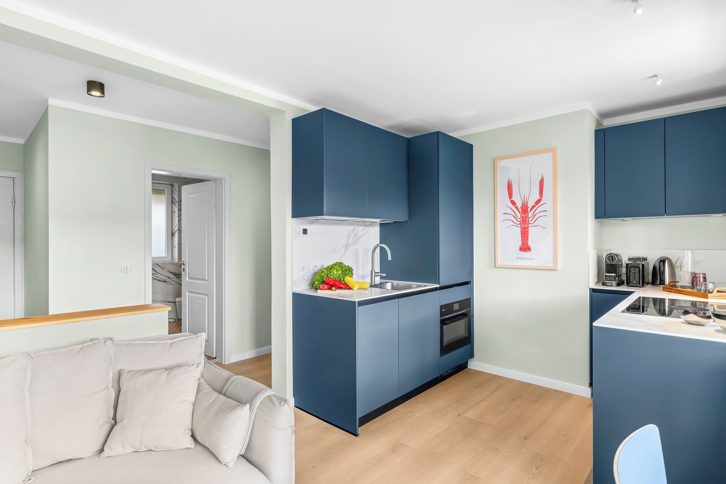 Eine moderne Küche mit blauen Schränken, einer weißen Arbeitsplatte und einem Spülbecken.