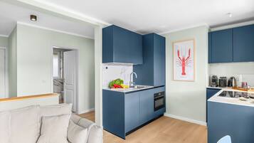 Eine moderne Küche mit blauen Schränken, einer weißen Arbeitsplatte und einem Spülbecken.