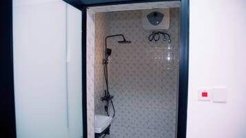 Een kleine badkamer met toilet, douche en wastafel.