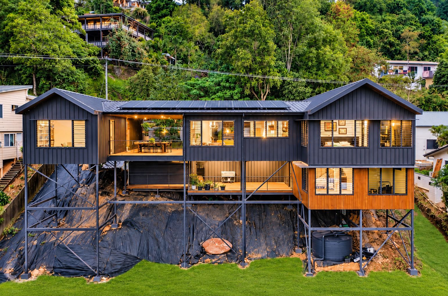 A modern two-story house with a flat roof, large windows, and a balcony.