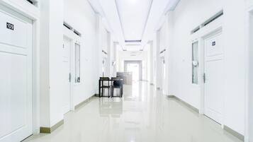 A long, narrow hallway with white doors numbered 109 and 104, leading to rooms.