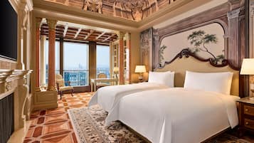 Una lujosa habitación de hotel con una cama grande, un escritorio y vistas a la ciudad.