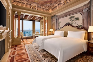 Una lujosa habitación de hotel con una cama grande, un escritorio y vistas a la ciudad.