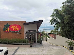 En restaurant, Lipa Grill, med synlig indgang og havudsigt i baggrunden.