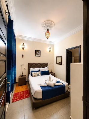 A hotel room with a bed, nightstands, a lamp, a ceiling light, and a door. - Riad Dar Benbrahim (Marrakech)