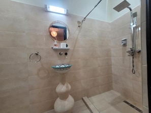 A bathroom with a shower, a sink with a decorative bowl, a towel ring, and a mirror. - Riad Dar Benbrahim (Marrakech)