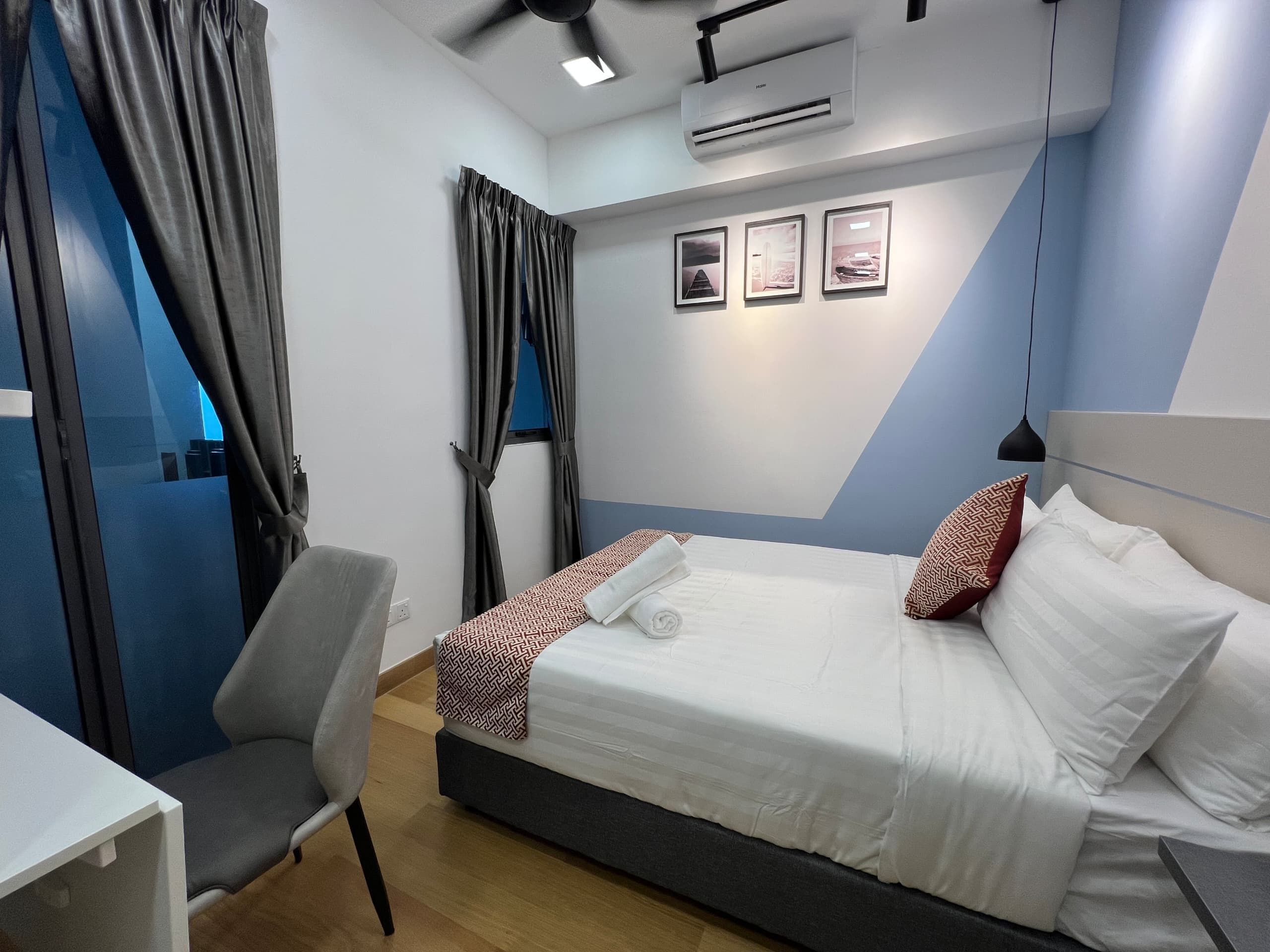 Una habitación de hotel moderna con una cama, un escritorio y una silla.