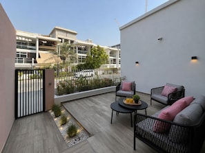 Eine Dachterrasse mit Sitzgelegenheit, einem Tor und Blick auf die umliegenden Gebäude.