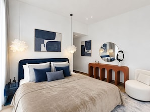 A modern bedroom with a large bed, a round mirror, and abstract artwork on the walls. - Pool Days. City Nights. Your Private VILLA Escape (دبي)