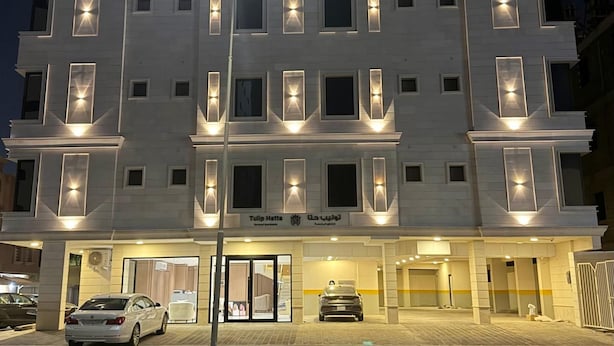 Ein mehrstöckiges Hotel mit beleuchteten Fenstern und einem Schild, das es als Hotel kennzeichnet.