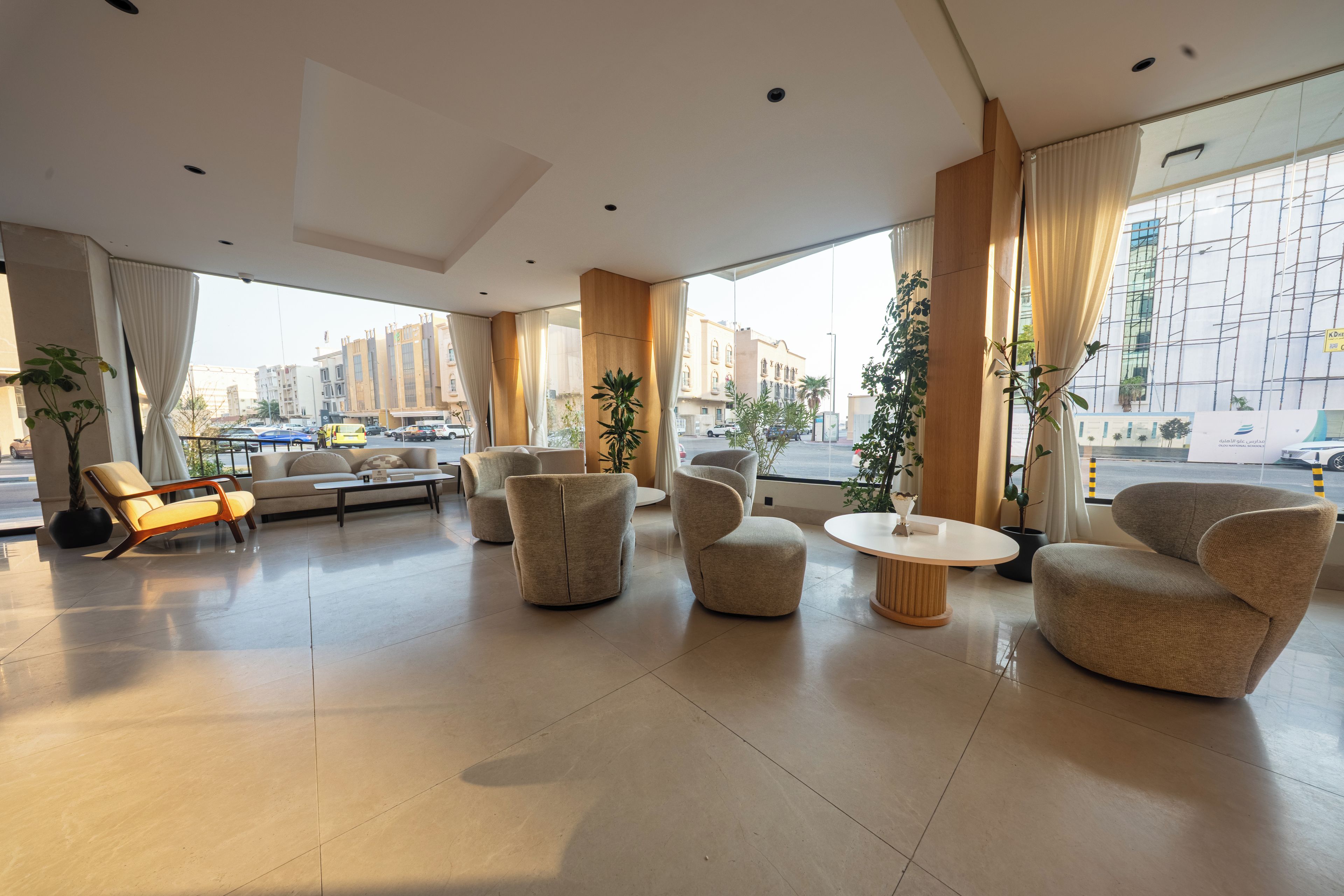 A spacious lobby with modern furniture, large windows, and a view of the cityscape.