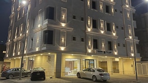 Ein mehrstöckiges Hotel mit beleuchteten Fenstern und einem Eingang im Erdgeschoss.