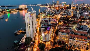 A cityscape with a prominent high-rise hotel, a river, and a busy waterfront area.