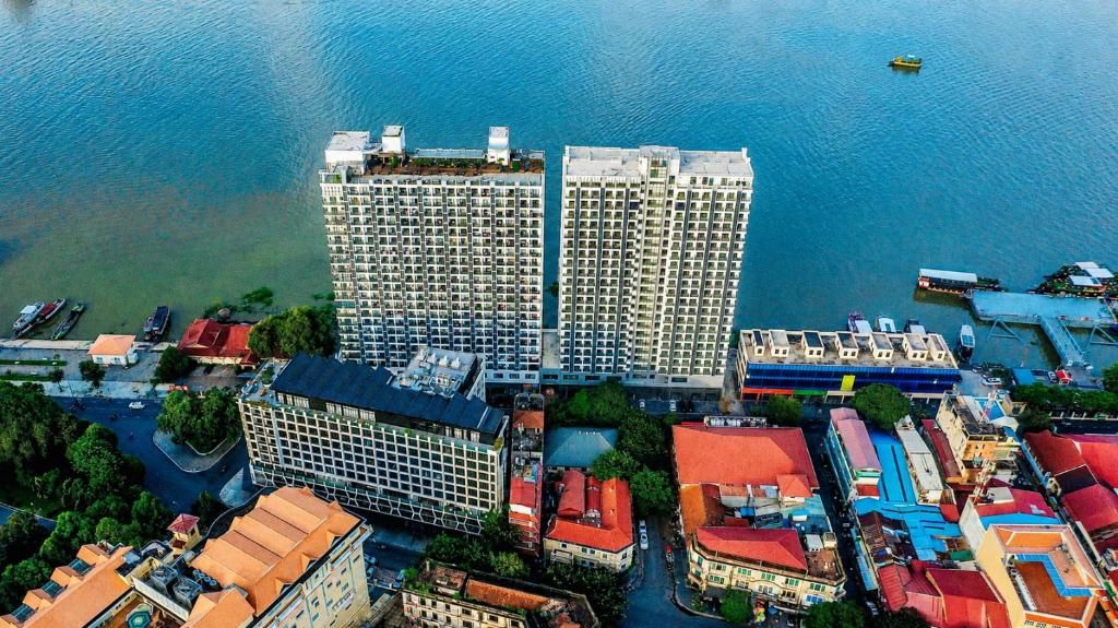 An aerial view of a coastal urban area with high-rise buildings, a marina with boats, and a mix of commercial and residential structures.