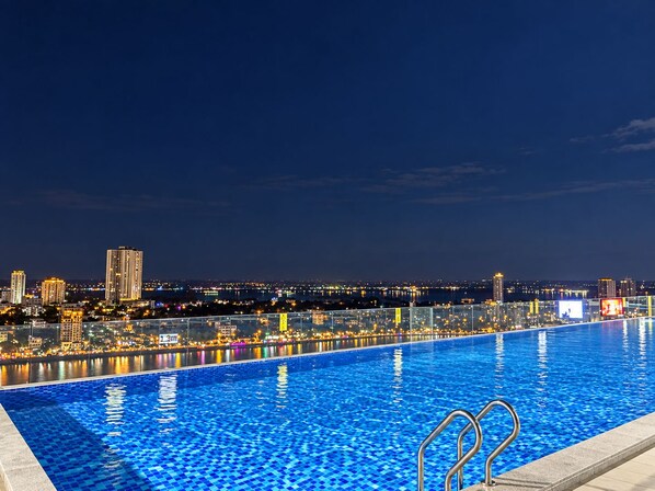 Una piscina con vista a un paisaje urbano de noche.