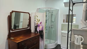 A bathroom with a wooden dresser, a glass shower enclosure, and a white sink. - Self-contained room in beautiful rural Queensland location with beautiful views (Illinbah)