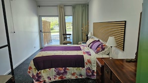A hotel room with a bed, a bedside table, a lamp, and a view of the outdoors. - Self-contained room in beautiful rural Queensland location with beautiful views (Illinbah)