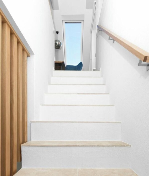 A staircase with white steps leading to a room with a window. - 272 - Apartment Lighthouse (Juist)