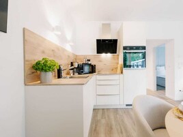 Una cocina moderna con encimera de madera, una cafetera y una planta en maceta.