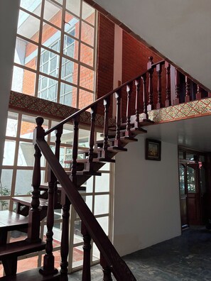 A wooden staircase with a handrail leading to a landing.