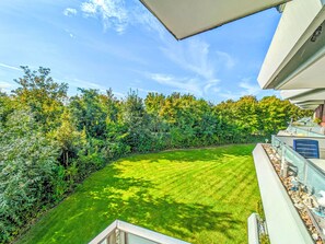 A well-maintained lawn with a curved pathway leading to a building with a balcony. - Albatros Royal by Interhome (Tossens)