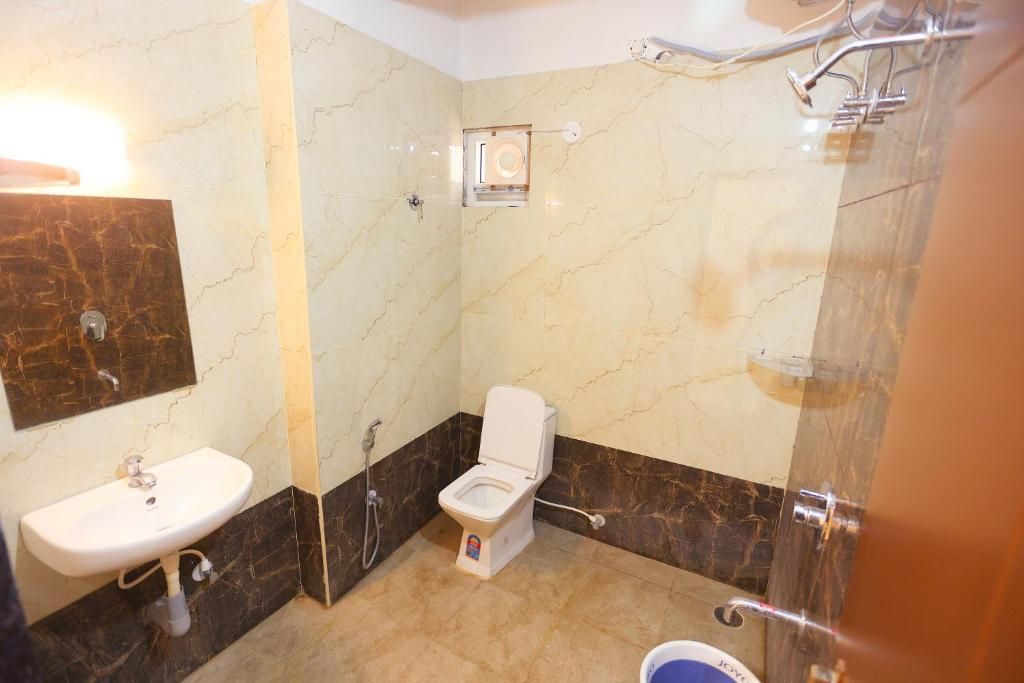 A bathroom with a white toilet, a sink, and a shower area.