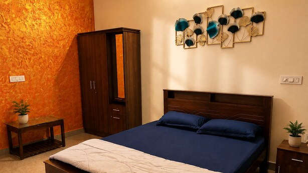 Una camera da letto con un letto, un armadio, un comodino e una decorazione appesa al muro.