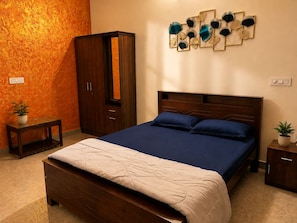 A bedroom with a bed, a wardrobe, a bedside table, and a wall-mounted decoration.