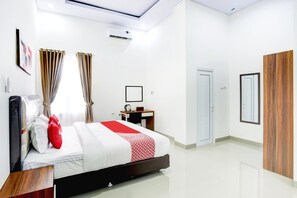 A hotel room with a bed, a desk, a wardrobe, and a door. - Stylish Double Suite Escape With Parking Access (Bandar Lampung)