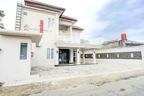 A two-story building with a balcony, a water tank on the roof, and a sign that reads 'Gria Baw Syariyah'. - Stylish Double Suite Escape With Parking Access (Bandar Lampung)
